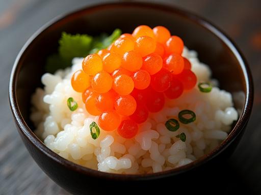 A small bowl of rice topped with vibrant sea urchin and salmon roe.